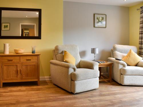 a living room with two chairs and a mirror at Old Orchard Cottage Near Eden in Luxulyan