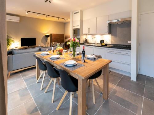 a kitchen and dining room with a wooden table and chairs at Duplex Apartment in the shopping street of Maasmechelen in Maasmechelen