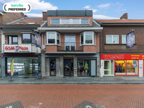 Un edificio en una calle de ladrillos con tiendas. en Maasmechelen Duplex Retreat, en Maasmechelen