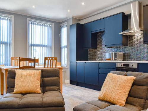 a living room with a couch and a kitchen at Folkestone Central in Folkestone
