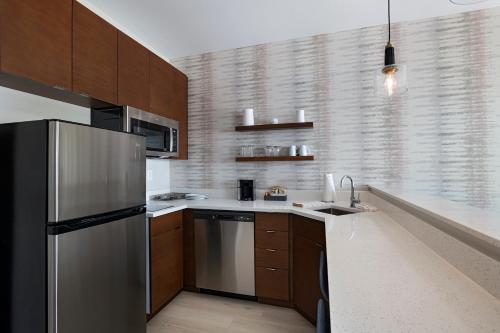 a kitchen with a stainless steel refrigerator and wooden cabinets at Residence Inn by Marriott Georgetown in Georgetown