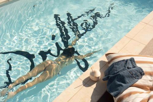 a man is swimming in a swimming pool at Drifter Byron Bay in Byron Bay
