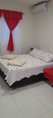 a bed in a room with a red curtain at Miss Margaritas´s House in San Andrés