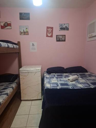 a bedroom with two twin beds and pictures on the wall at Hostel & Pousada UFPE INN in Recife
