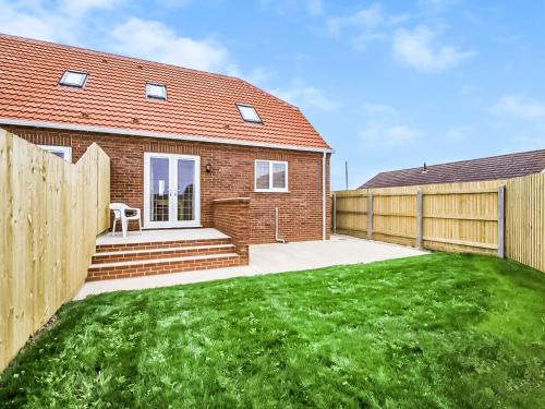a brick house with a fence and a yard at 4 Dawson Court - Uk33414 in Mablethorpe