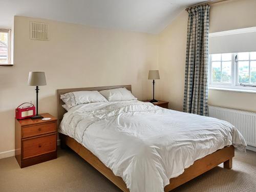 a bedroom with a large bed and a window at The Loft in Ilminster