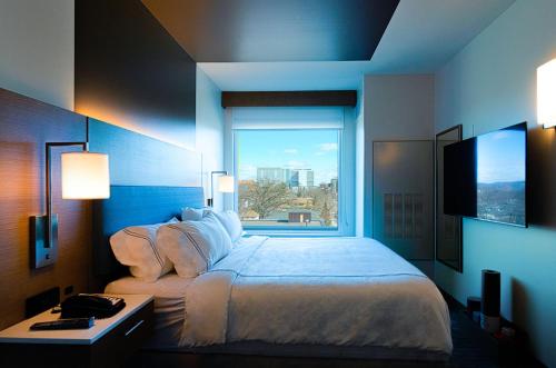 a bedroom with a large bed with a large window at EVEN Hotels Rochester - Mayo Clinic Area by IHG in Rochester