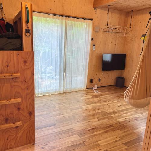a living room with a wooden floor and a television at SNUG CAMP HOUSE - Vacation STAY 98114v in Okubo