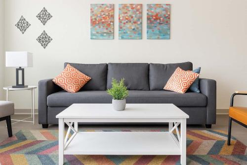 a living room with a couch and a white coffee table at Stunning Nulu 1BR CozySuites 01 in Louisville
