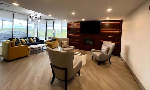 a living room with couches and chairs and a tv at Comfort Inn in Princeton