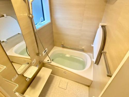 OkuboにあるSNUG CAMP HOUSE - Vacation STAY 98115vの浴槽と鏡のある小さなバスルーム