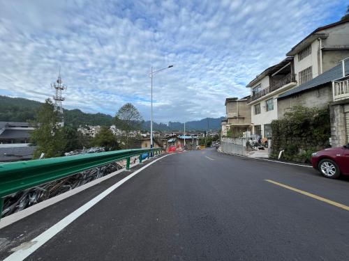 an empty street in a town with a green bridge at 张家界畔山驿栈 in Zhangjiajie