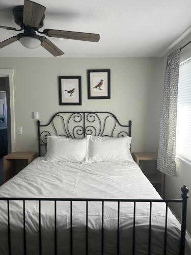 a bedroom with a bed with white sheets and a ceiling fan at Cozy Corner in Federal Way in Federal Way