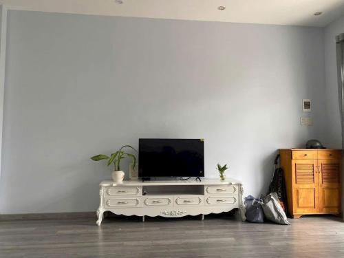 a living room with a tv on a white entertainment center at Nhà nguyên căn 3 phòng ngủ in Ấp Bình Hưng