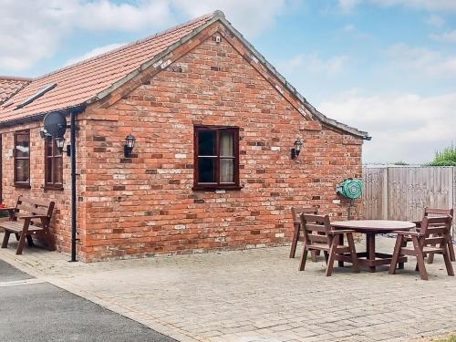 a brick building with tables and chairs in front of it at Alfie's Abode in Ingoldmells