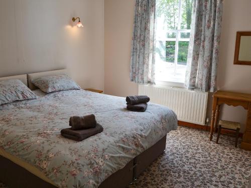 a bedroom with a bed with two towels on it at The Waiting Rooms in Cawston