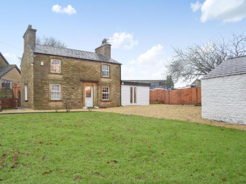 an old brick house with a large yard at Brookside Cottage in Forton