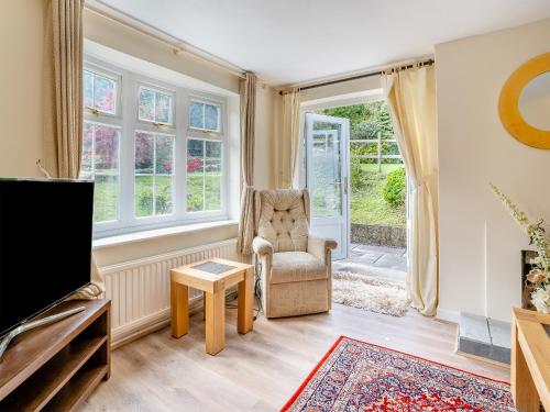 ein Wohnzimmer mit einem Stuhl und einem TV in der Unterkunft The Retreat Cottage in Machen