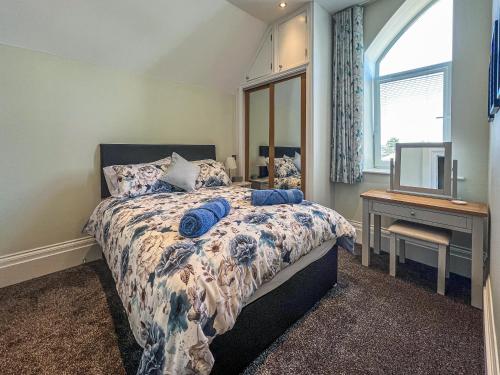ein Schlafzimmer mit einem Bett, einem Schreibtisch und einem Fenster in der Unterkunft Old School Mews Too in Shanklin