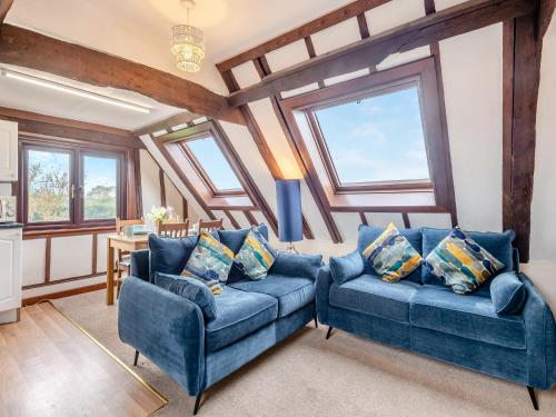 a living room with two blue couches and windows at Plover - Uk48174 in Colchester