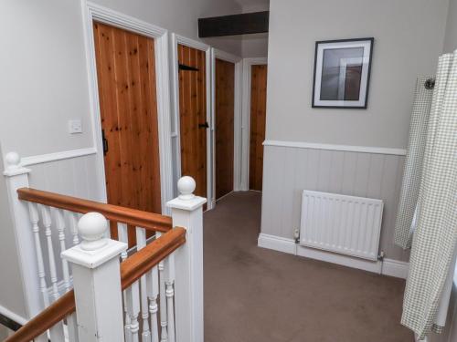 a hallway with a staircase with a wooden door at Goldfinch in Lucker