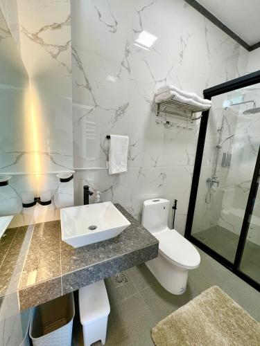a bathroom with a toilet and a sink at Panika cozy rooms in Malaybalay