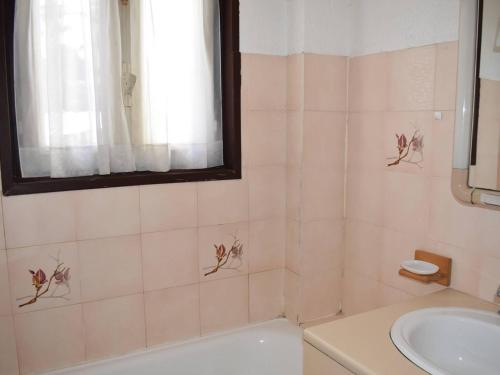 a bathroom with a sink and a toilet and a window at Appartement 3 pièces, plein sud, centre de Font-Romeu - FR-1-580-136 in Font-Romeu