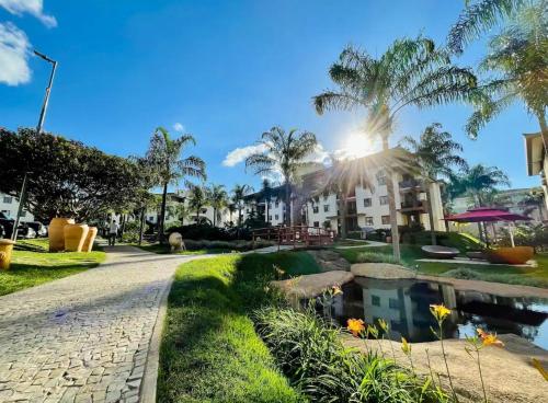a resort with a pond and palm trees at Life Resort, Trabalho e Lazer! in Brasilia