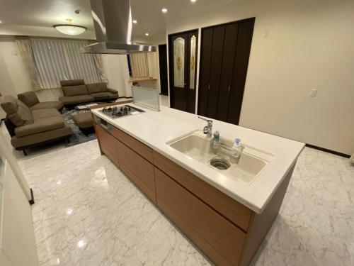 a bathroom with a sink and a living room at Empire Skyridge Hotel - Vacation STAY 17783 in Chikugo