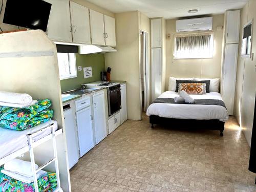 a small kitchen with a bed in a small room at Kalaru Holiday Park in Tathra