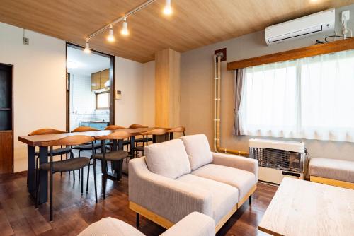 una sala de estar con un sofá y una mesa en Hatsune 観光拠点 多人数向け 閑静な住宅街, en Otaru