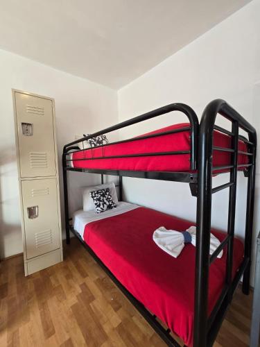 a bedroom with two bunk beds with red sheets at Grand House in Chicago