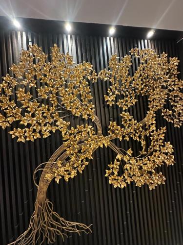 a gold tree in front of a black curtain at Sakura Sky Residence in Bangkok