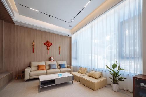 HuangshanにあるHuazhu Songshiju Homestayのソファとテーブルのあるリビングルーム