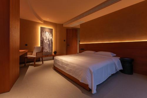 a bedroom with a large white bed and a desk at Roy Hotel-Tianya Town Store in Sanya