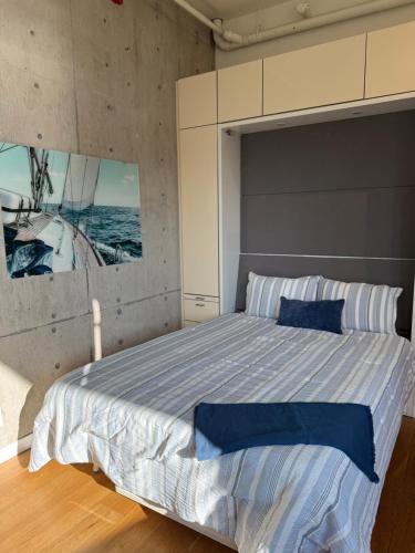a bedroom with a large bed with a painting on the wall at Downtown Studio Rental in Victoria