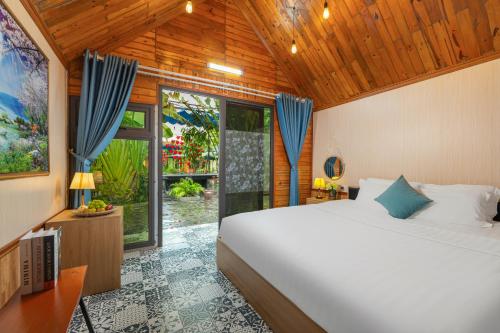 a bedroom with a bed and a large window at Tam Coc Forest Bungalow & Spa in Ninh Binh