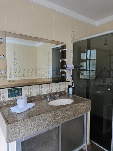 a bathroom with a sink and a mirror at Hotel Brasil in São Lourenço