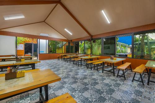 a restaurant with tables and chairs and windows at Tam Coc Forest Bungalow & Spa in Ninh Binh