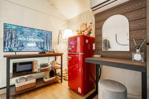 a room with a red refrigerator and a tv at Shinchon Maven Hotel in Seoul