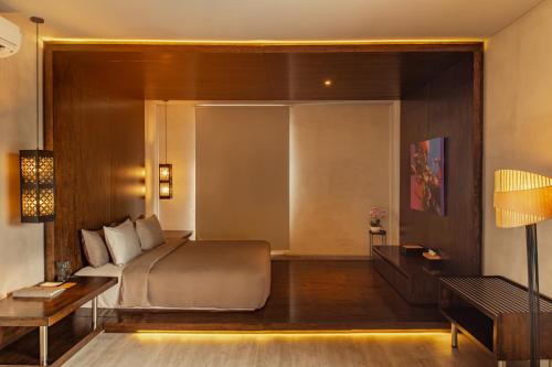 a bedroom with a bed and a table and a desk at INSPIRA Seminyak in Seminyak
