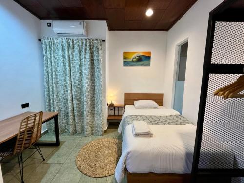 une chambre avec deux lits, une table et un bureau dans l'établissement Authentic Nusa Dua home, 4BR, Renovated 2025, à Nusa Dua