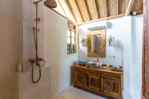 a bathroom with a shower and a wooden dresser at BoHo Bingin Beach Bali in Uluwatu