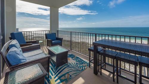 a balcony with a table and chairs and the ocean at Phoenix VI 61408 in Orange Beach
