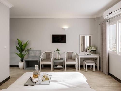 a white living room with a table and chairs at Premium Hotel Saigon - Ben Thanh Market in Ho Chi Minh City