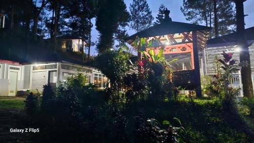 CigunturAlvaro Resort Bukit Angin的院子里带雨伞的房子