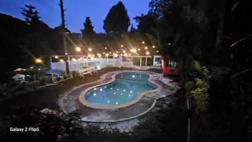 a swimming pool in a yard at night at Alvaro Resort Bukit Angin in Ciguntur