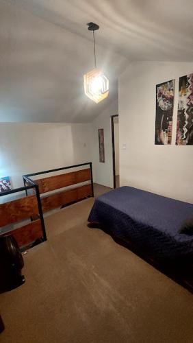 a bedroom with a bed and a pendant light at La Loma del Valle in Tanti