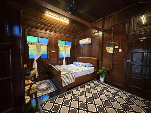a bedroom with a bed in a room with wooden walls at Homestay Singgah Keluarga Warisan Abg Tam in Kepala Batas