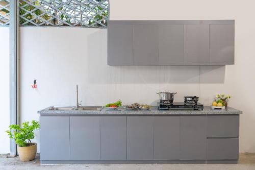 a kitchen with white cabinets and a counter top at Homestay Song Ngọc in Ấp Sung Xuân